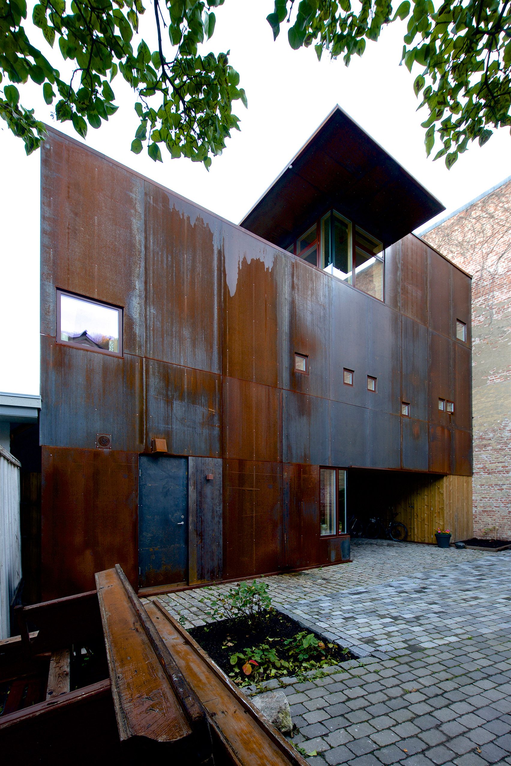 Weathering Steel Panels Create Rusty Walls For House In Oslo's Old Town Throughout Weathered Steel Bookcases (View 12 of 15)